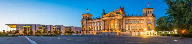 The iconic facade of the Reichstag, home of the Bundestag, German Parliament, illuminated at dusk in the heart of Berlin, Germany’s vibrant capital city.