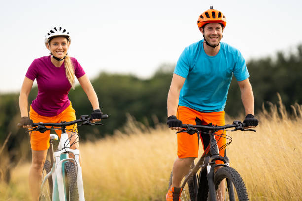 istock happy couple looking forward cycling on e mountain bikes in rural landscape 1007781768