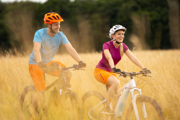 istock carefree cheerful couple biking through high grass 1007781850