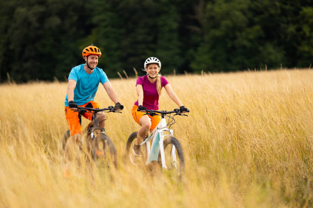 istock happy couple cycling in high dry grass 1007781894