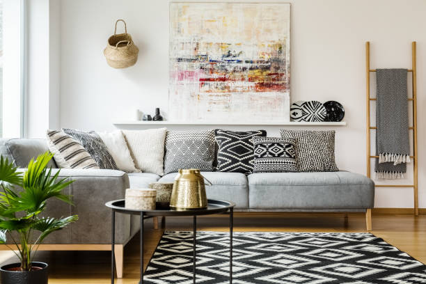거실 인테리어 테이블 및 그림에서에서 회색 코너 소파에 꽃무늬 베개. 실제 사진 - cushion sofa pillow indoors 뉴스 사진 이미지