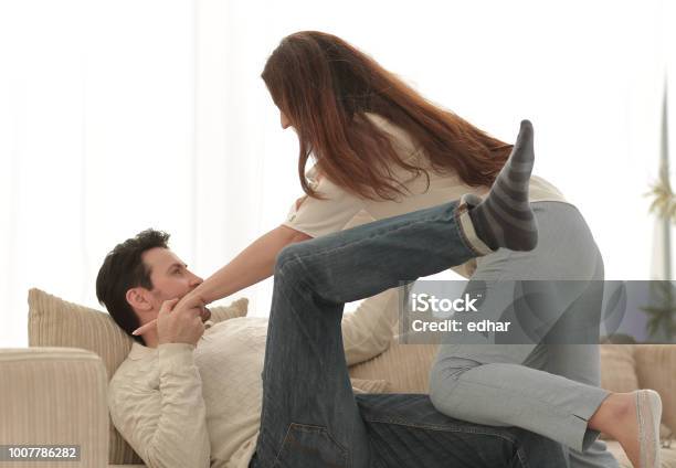 Couple Flirting With Each Other In The Living Room Stock Photo - Download Image Now - Adult, Affectionate, Backgrounds