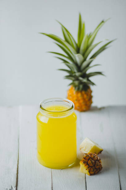 istock Pineapple juice In a glass bottle White wood background 1007786418