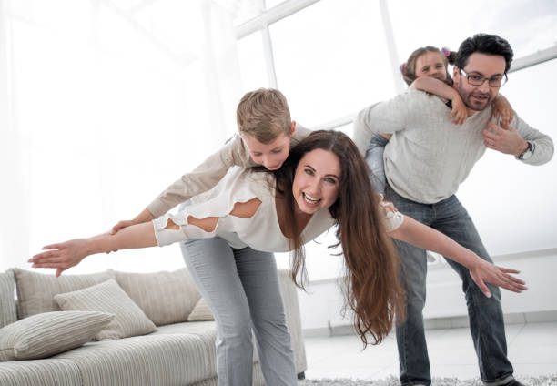 istock loving parents playing with children at their home 1007786728