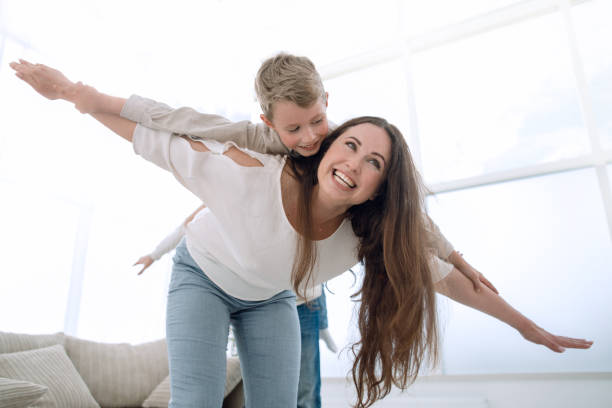 istock mother plays with her son in a spacious living room 1007786852