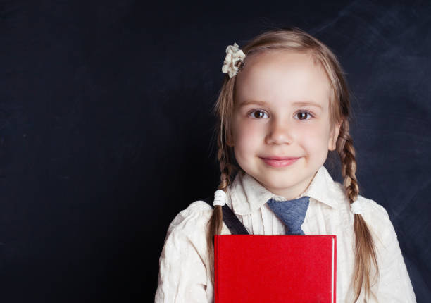 Kid Creativity Education Concept, Child Learning Art MathemaCute little girl in schoo uniform clothes reading a book and smiling. Back to school, elementary school lesson and education concept.tics Formula, School Boy Ideas on Black Chalk Board Cute little girl in schoo uniform clothes reading a book and smiling. Back to school, elementary school lesson and education concept. back to schoo stock pictures, royalty-free photos & images