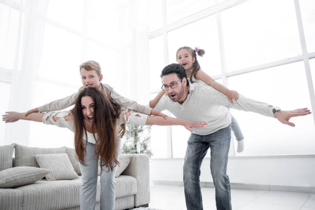 istock happy parents play with children at home 1007787032