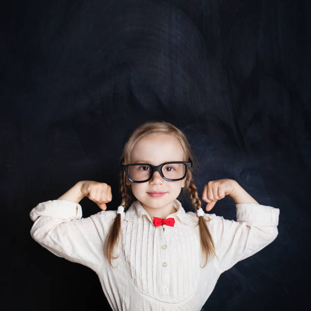 istock Cute Child on Empty Chalkboard Background. School Girl Power, Creativity and Education Concept 1007787232