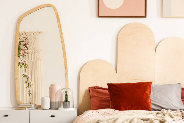 istock Red cushions on bed with headboard next to dressing table with mirror in bedroom interior. Real photo 1007789672