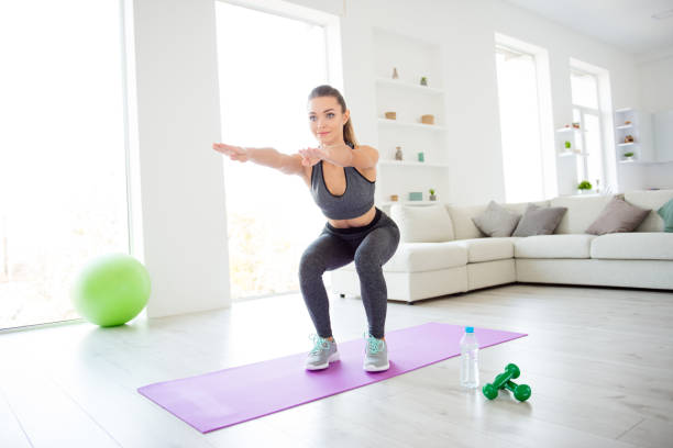 vitalidad del estilo hermosa figura concepto de cuerpo y alma sano. retrato de foto de hermosa muy encantadora hermosa centrado seguro deportivo la señora calza leggins apretados haciendo sentadilla contra la ventana del desván - aerobics beautiful bottle body fotografías e imágenes de stock