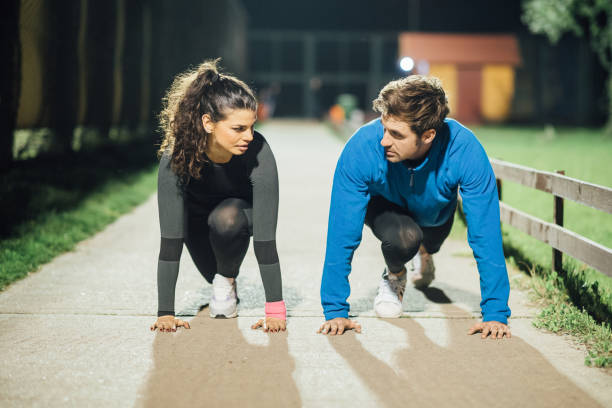 istock Athletic couple looking at each other while exercising outdoors 1007801610