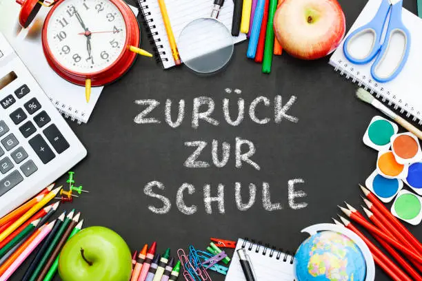 chalkboard with the text ,,zuruck zur schule''( back to school ) written in German