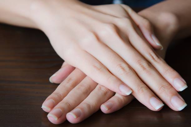 mains de femme montrant avec belle manucure sur fond en bois. - polish culture photos et images de collection