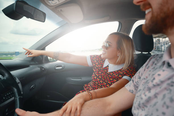 istock Excited woman showing something while sitting in the car 1007814776
