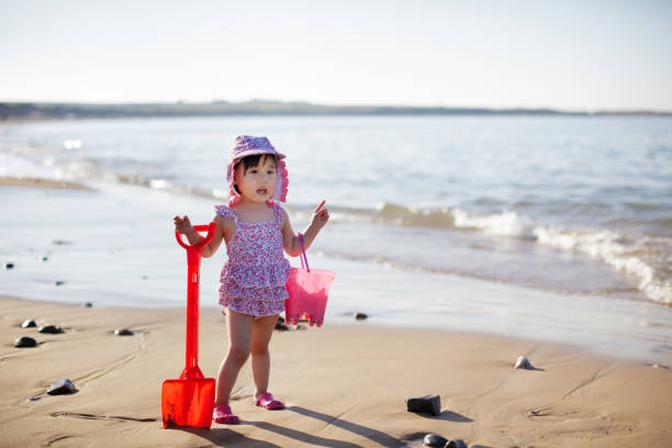 istock baby girl playing at summer beach 1007817312