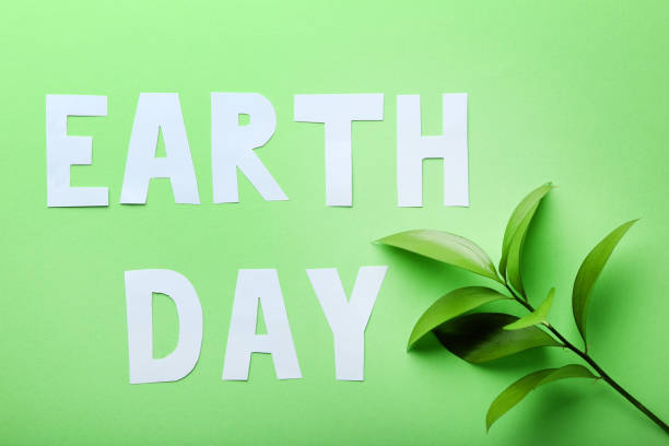 istock Inscription Earth Day with young plant on green background 1007817638