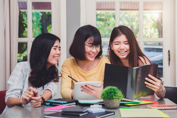 istock Happy young university students studying with books in library. 1007817690