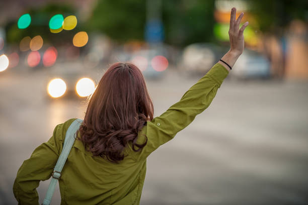 catching the attention of a passing taxi cab - chamada de fotografia imagens e fotografias de stock