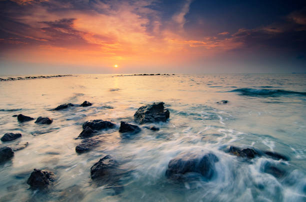 istock soft wave hitting the rock on the tropical beach over magical sunlight color 1007824448