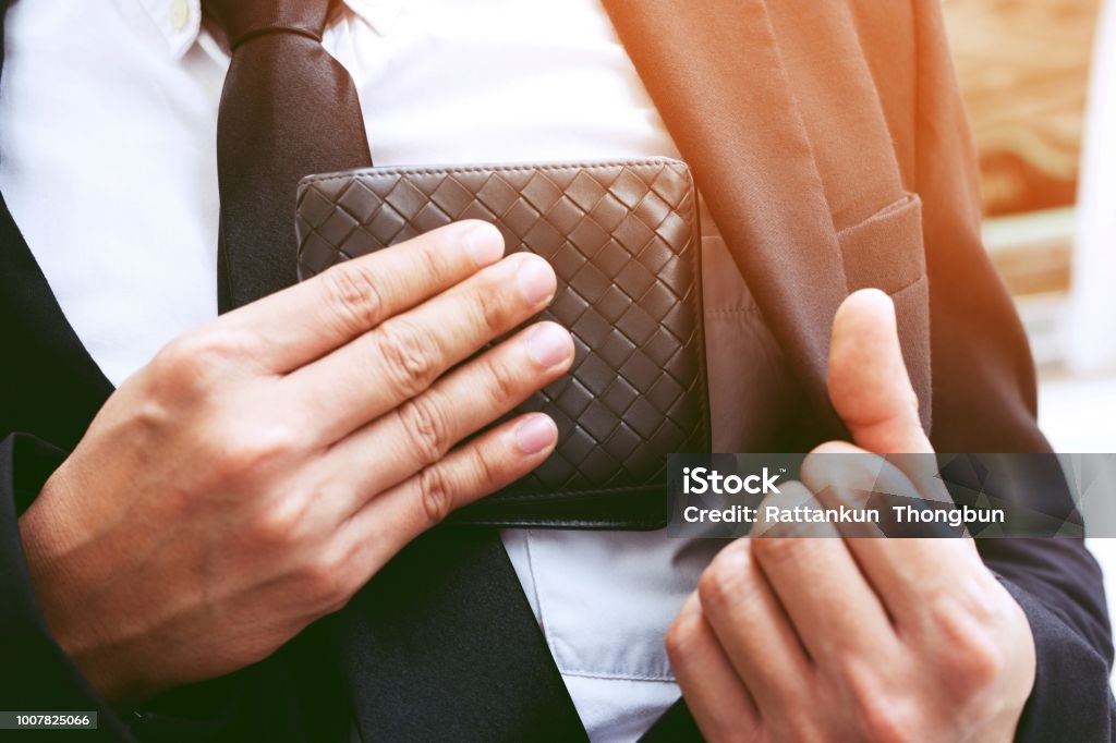 Confident businessman young posing in save keeping your wallet in the suit pocket inside of his. Wallet Stock Photo