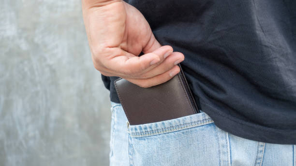 istock Men hold a brown wallet from a jeans pocket. 1007828476
