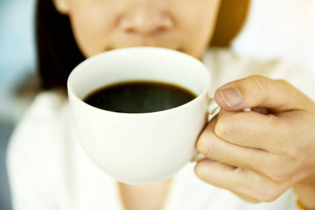 istock Women holding coffee cup and drink coffee in morning 1007839900