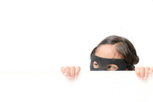 Female power, protest, women rights concept. Brunette superhero girl in black dress and red face mask make boxing using hands on a camera with urban city background. High quality image