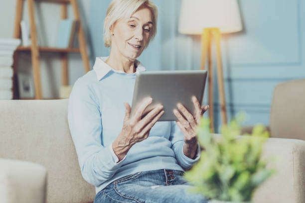istock Positive delighted female person looking at her gadget 1007843828