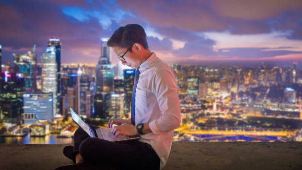 istock Asian business man using laptop and digital tablet in Singapore 1007845304