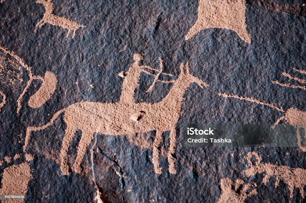 Native american hunter petroglyph Hunter petroglyph on Newspaper Rock in Canyonlands National Park, Southwest USA Cave Painting Stock Photo
