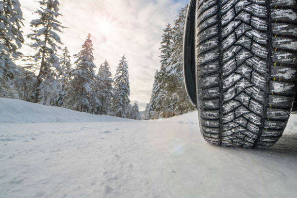 car with winter tires on snowy road stock photo