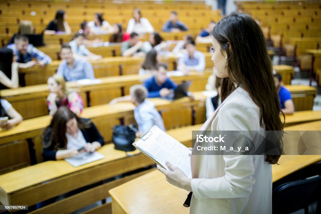 Students sitting in amphitheater Students sitting in amphitheater and studying Assistant Stock Photo