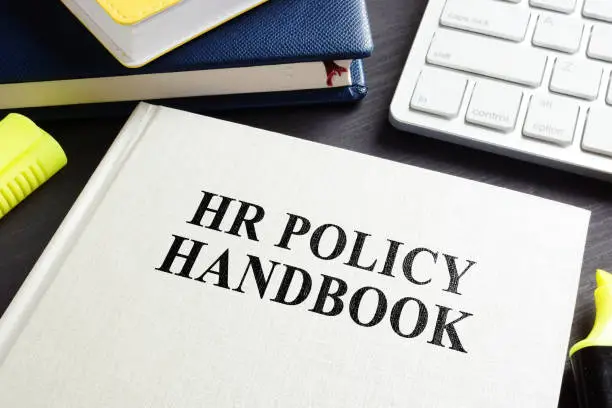Photo of HR policy handbook on an office desk.