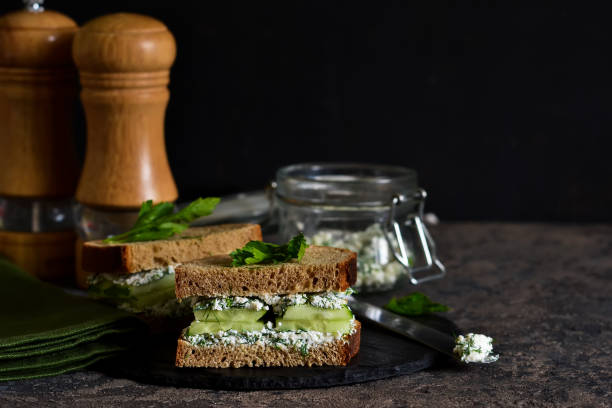 istock Vegan sandwich with cheese, cucumber and spices on a dark background. 1007951146
