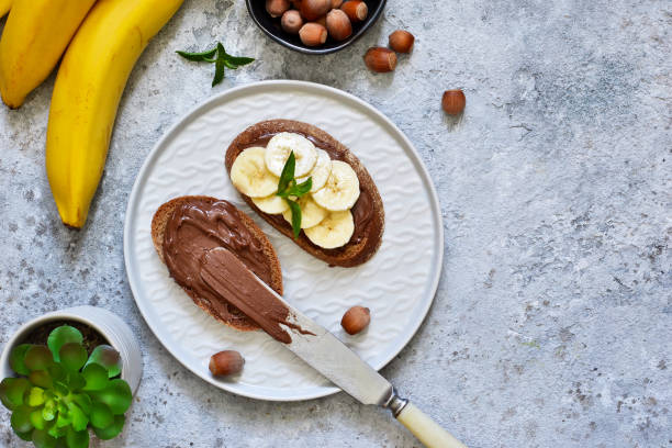 istock Grilled toast with chocolate paste and banana for breakfast on a concrete background. 1007951260