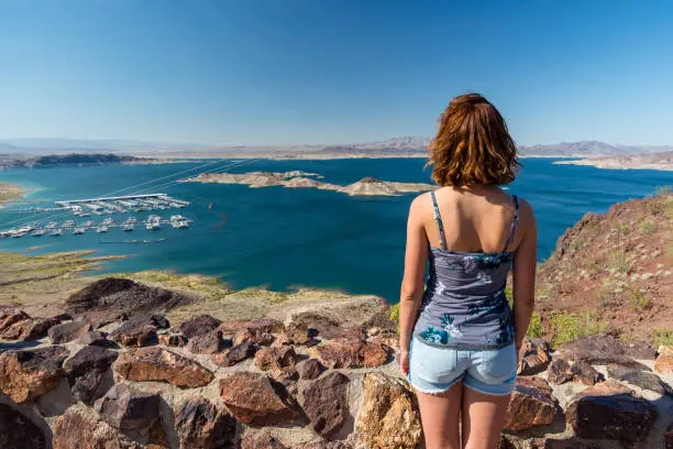 Young woman is looking at the Lake Mead National recreation area as seen from the viewpoint above Hoover Dam in Nevada, United States of America