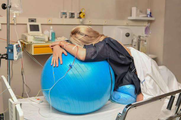 frau während der kontraktionen auf einen fitnessball entbindung krankenhaus - muscular contraction stock-fotos und bilder
