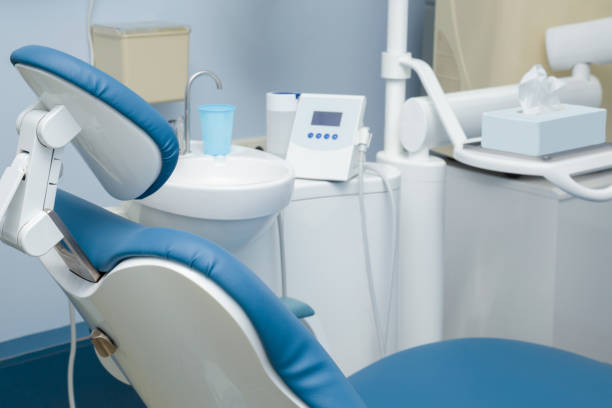 moderne zahnarztpraxis. blauer stuhl mit verschiedenen geräten und zubehör. - dentists chair dentist office chair orthodontist stock-fotos und bilder