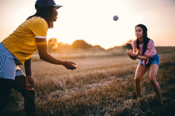 Photo of Cute friends playing baseball together outdoors