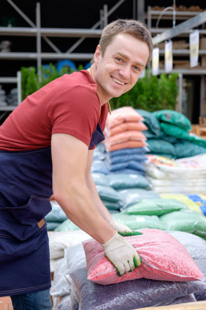 istock young man worker in plant market greenhouse at work 1007986790