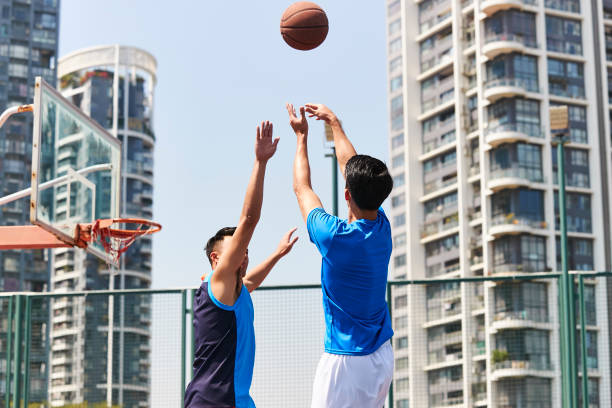 istock young asian adults playing basketball 1007990380