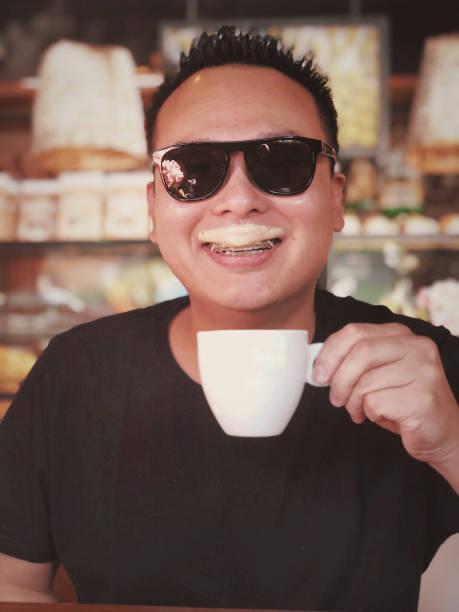 Portrait of mid adult poor asian man with hands joined, looking at camera. Fisheye shot