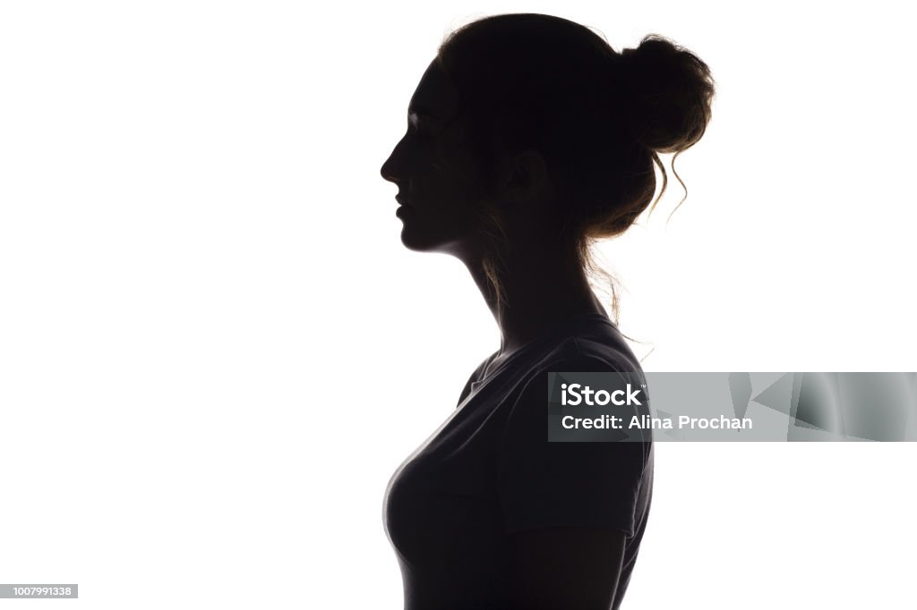 silhouette profile of beautiful girl on a white isolated background silhouette of a young graceful woman on a white isolated background, face profile of a beautiful girl, concept beauty and fashion In Silhouette Stock Photo