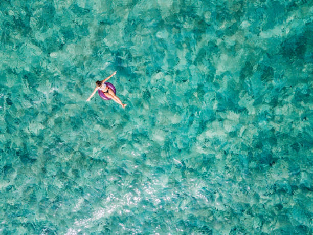 istock Woman lying on inflatable ring floating in the sea 1008002102