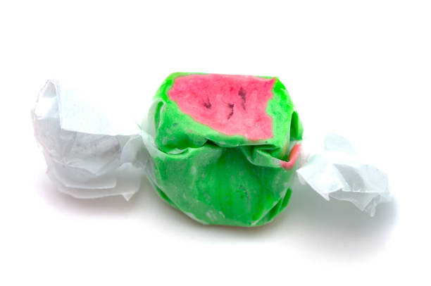 singolo pezzo di acqua salata di anguria taffy su sfondo bianco - taffy foto e immagini stock