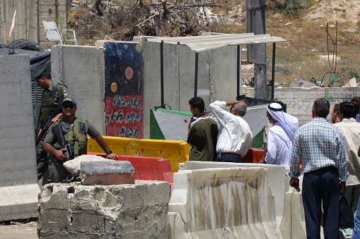 Jerusalem, Israel - Aug. 9, 2002:  Palestinians wait at a checkpoint to enter the city from the West Bank.