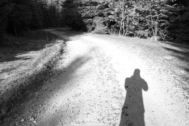 istock Shadow of a man on the mountain road black and white 1008027916