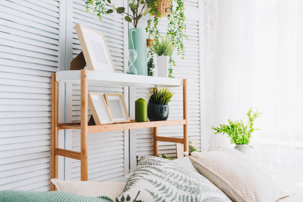 istock Cozy brightly lit room corner decorated with various objects such as picture frames, plants and pillows 1008030406