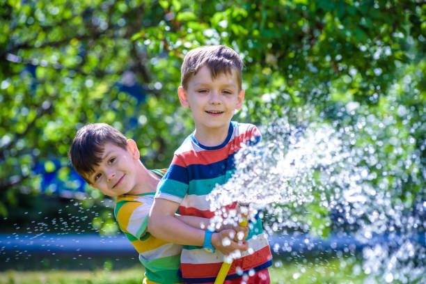 istock Brothers having fun splash each other with water in the village 1008030722