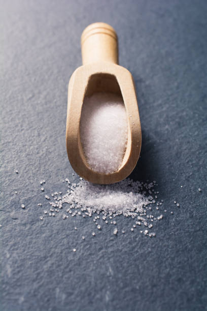 istock Wooden Kitchen Scoop With White Grain Salt On Slate Stone, Front View 1008039080